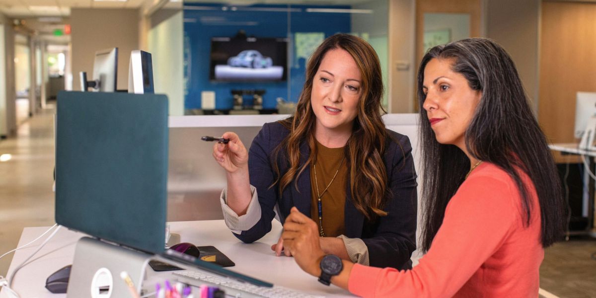 Women working at computer screen together